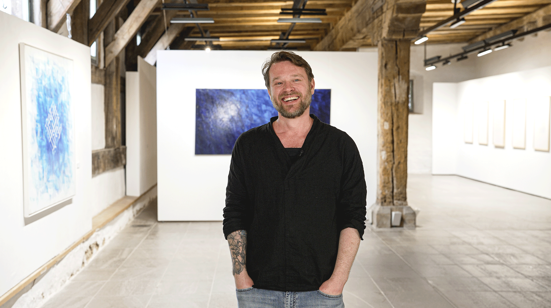 Wolff in einem Ausstellungsraum vor einem Gemälde.